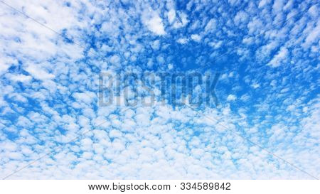 Panorama of the blue sky with lots small white fleecy clouds - texture and background 