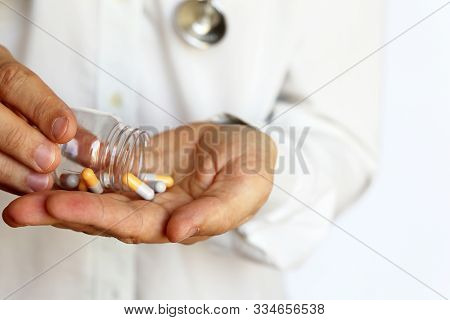 Doctor With Bottle Of Pills, Man With Stethoscope Giving Medication In Capsules. Concept Of Dose Of 