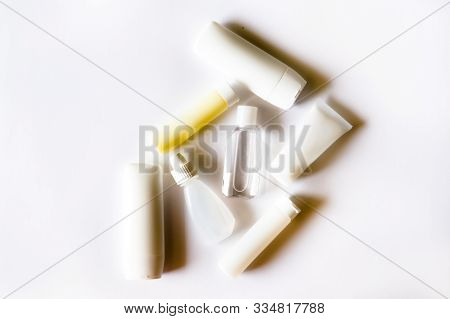 White Cosmetic Mini Plastic Bottles With Deep Shadows Monochrome Background. Ecological Concept.