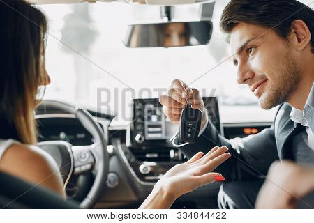 Stylish And Elegant Couple In A Car Salon