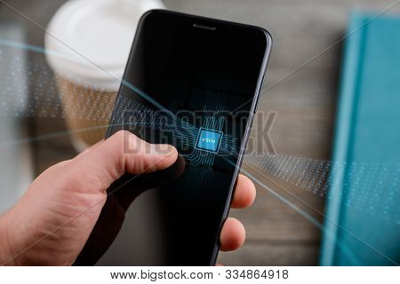 Hand Holding A Smart Phone With E-sim Chip, Electronic Concept
