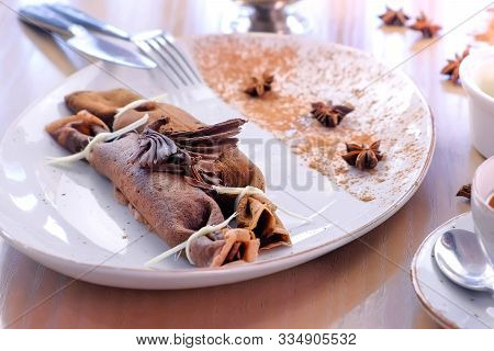Chocolate Russian Pancakes, Blini With Curd Filling On The Plate. Served With A Cup Of Tea And Butte