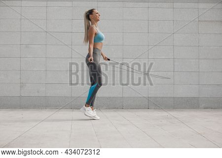 A Young Athlete Does Stretching And Warm-up Before Doing Yoga. Fitness Girl Workout In The Gym, Whit