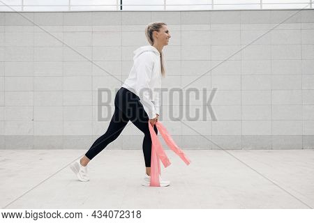 A Young Athlete Does Stretching And Warm-up Before Doing Yoga. Fitness Girl Workout In The Gym, Whit