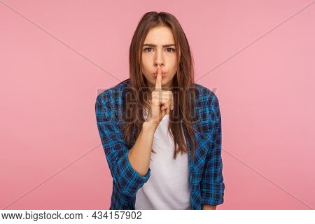 Shh, Dont Speak. Portrait Of Worried Unhappy Girl In Checkered Shirt Holding Finger On Lips Showing 