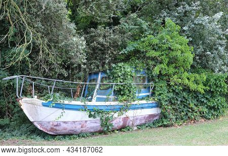 Wreck Of An Abandoned Boat All Covered With Grass And Many  Plants