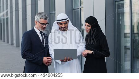 Mixed Business Team In Dubai. Business Meeting With Men Wearing Kandura And Western People At The St