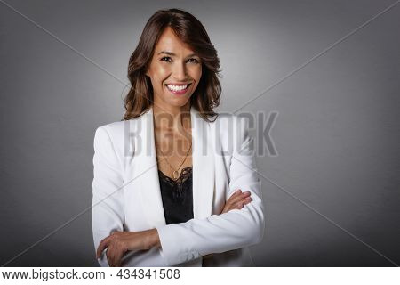 Studio Portrait Shot Of Attractive Middle Aged Woman With Toothy Smile Wearing Blazer While Standing