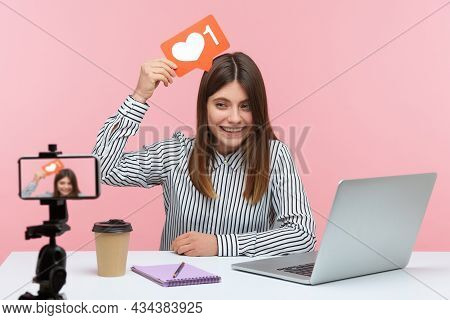 Smiling Positive Woman Blogger In Striped Shirt Recording Video For Followers Holding Like Sign Abov