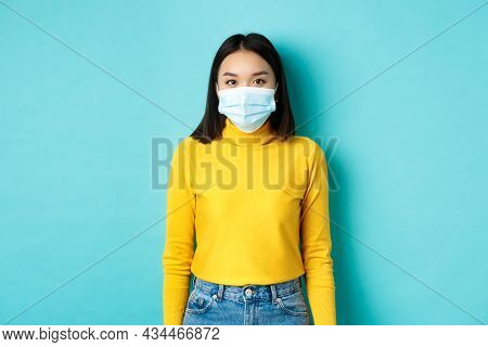 Covid-19, Social Distancing And Pandemic Concept. Teenage Asian Woman In Medical Mask, Looking At Ca