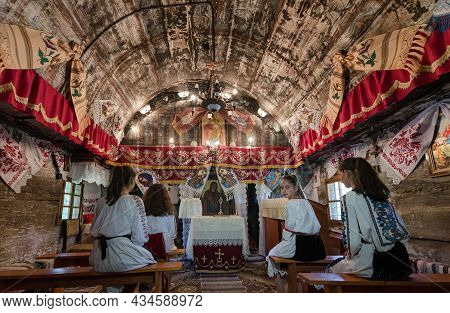 Salaj, Romania-may 12, 2018: Young Girls Wearing Traditional Romanian Costumes Praying In A Old Wood