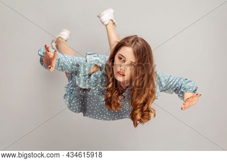 Beautiful Girl Levitating In Mid-air, Falling Down And Her Hair Messed Up Soaring From Wind, Model F