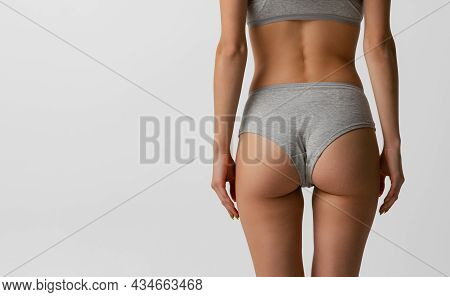 Back View Of Sportive Body, Bottocks Of Young Woman In Grey Bottocks Isolated On Gray Studio Backgro