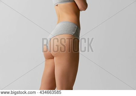 Back View Of Sportive Body, Bottocks Of Young Woman In Grey Bottocks Isolated On Gray Studio Backgro