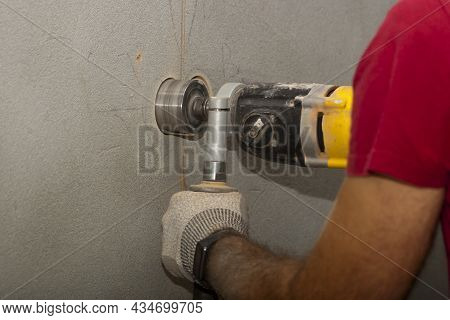 Drilling Holes In The Wall For An Electrical Outlet Box Or Switch. The Technician Uses A Drill To Dr
