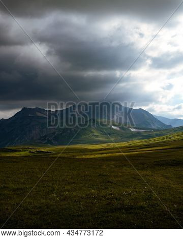 Beautiful photography of the mountain Oshten. Dramatic sky in the background and sun rays. Idea of tourism and hiking, breathtaking nature. High mountain in Russia.