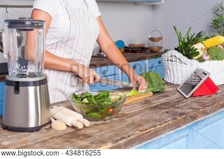 Closeup Of Female Hands Chopping Cutting Vegetables With Knife, Woman In Apron Cooking Salad In Kitc