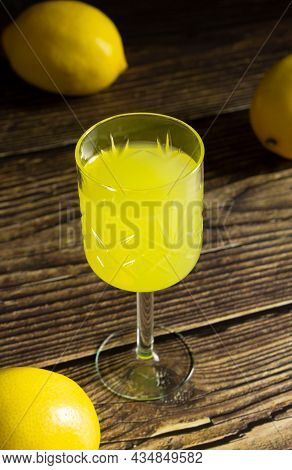 Limoncello Liqueur Or Poncha Drink In A Glass Textured Vintage Glass On A Wooden Rustic Table With L
