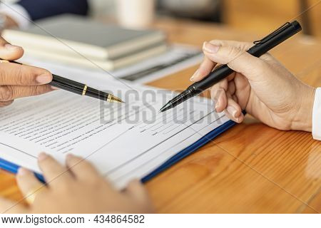The Manager Points To The Employment Contract For The Applicant To Sign As An Agreement To Work, The
