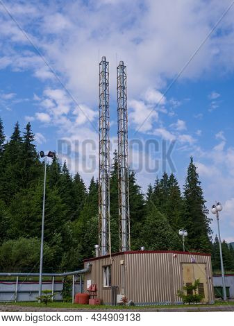 Modern Small Boiler House With Two Big Pipes Against The Blue Sky And Green Forest In Sunny Summer D