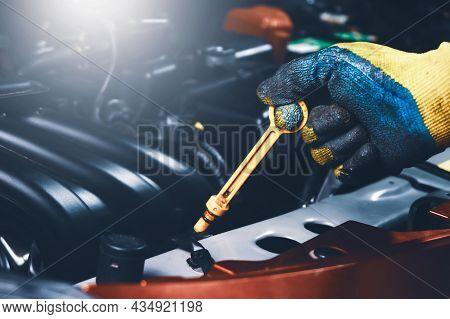 Mechanic Hand Pulling Up Oil Dipstick Of The Car Engine For Checking Oil Level