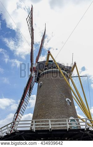 Closeup Of Tower, Yellow Start Bars And Blades At Korenbloem Windmill, Blue Sky And Abundant White C