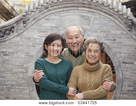 Grandparents and granddaughter in front of round arch, Beijing