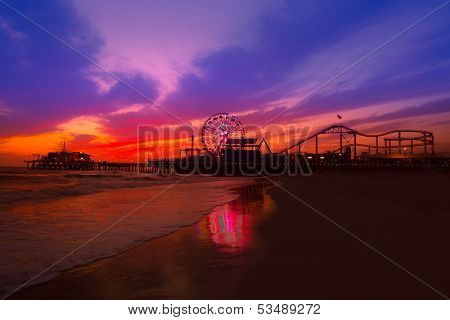 Santa Monica California sunset on Pier Ferris wheel and reflection on beach wet sand