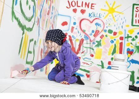 Young Artist paitning a white room with a smile on her face