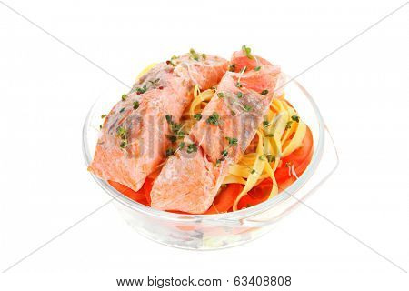 fresh fried natural pink salmon on italian traditional tagliatelle backed with tomato and vegetables isolated over white background