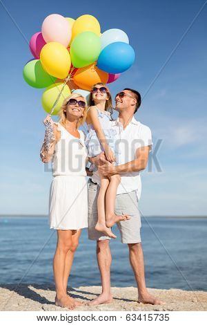 summer holidays, celebration, children and people concept - happy family with colorful balloons at seaside