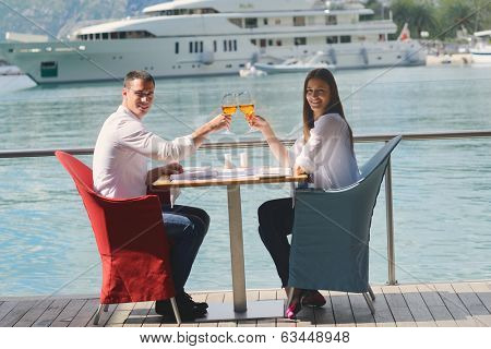 happy young couple having lanch at beautiful restaurant on by the sea on  beach