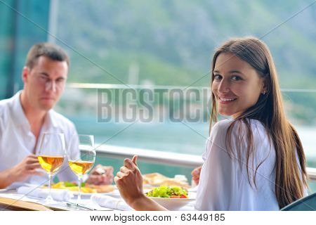 happy young couple having lanch at beautiful restaurant on by the sea on  beach