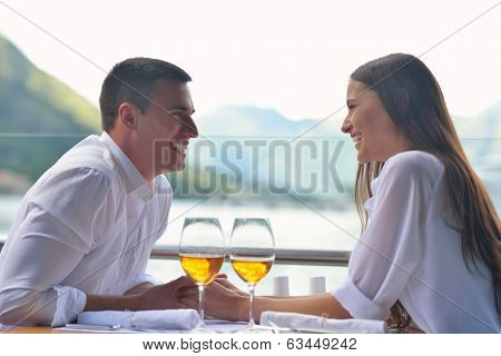 happy young couple having lanch at beautiful restaurant on by the sea on  beach