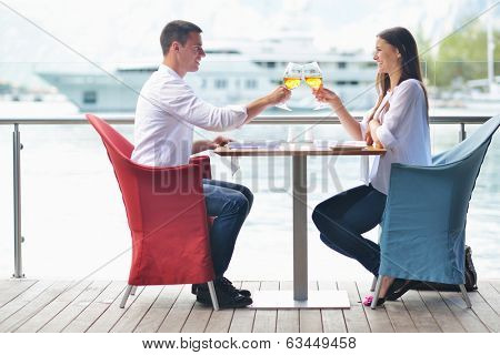 happy young couple having lanch at beautiful restaurant on by the sea on  beach