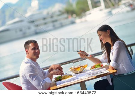 happy young couple having lanch at beautiful restaurant on by the sea on  beach