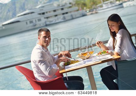 happy young couple having lanch at beautiful restaurant on by the sea on  beach