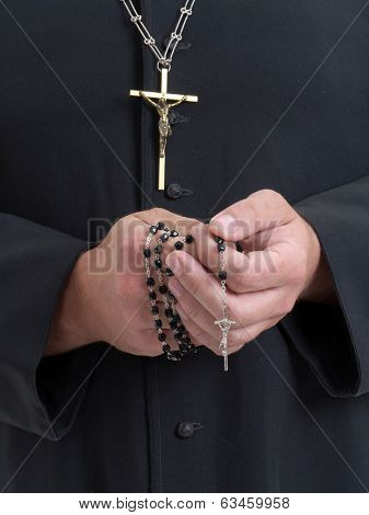 Closeup of catholic priest's hands holding the rosary