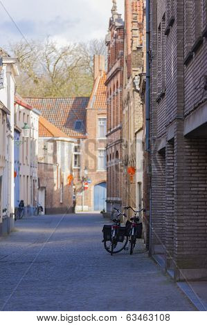 Two Bicycles Leaning Against Brick Buildings Bruges