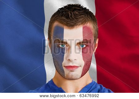 Composite image of serious young france fan with facepaint against digitally generated france national flag