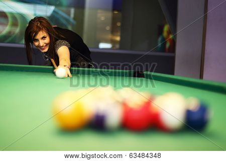 Young brunette girl playing snooker