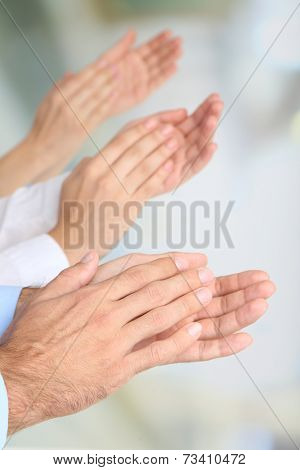 Clapping hands on bright background
