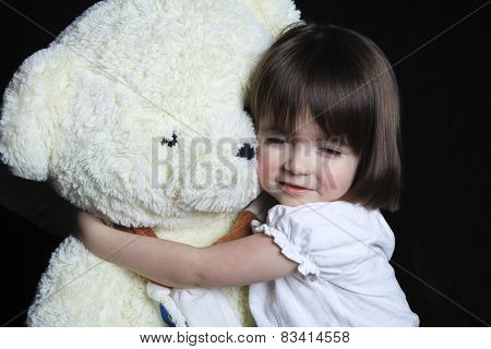 a little girl with bear on a black background