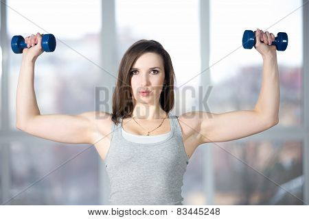 Sporty Young Woman Lifting Dumbbells