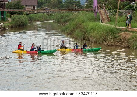 Vang Vieng, Lao P.d.r. - October 24 : Unidentified Tourists Are Rowing Kayak Boats In Song River On
