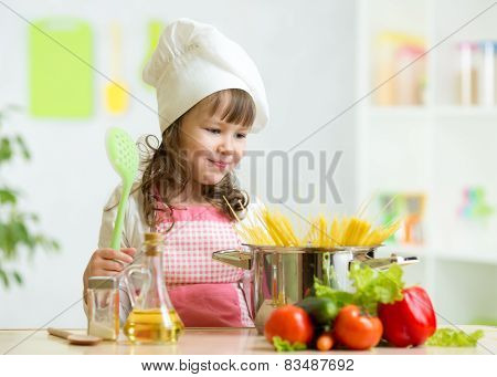 Cook kid makes healthy vegetables meal in the kitchen