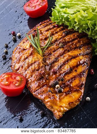 Steak chicken breast olive oil cherry tomatoes pepper and rosemary herbs.