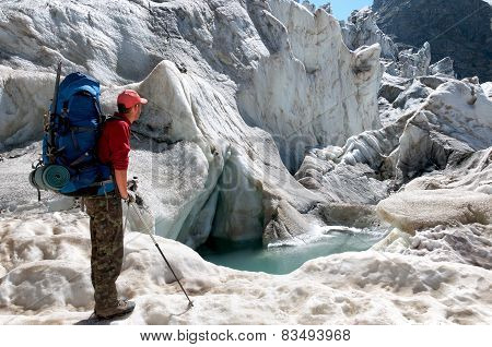Tourist with a large backpack looks at highest glacier