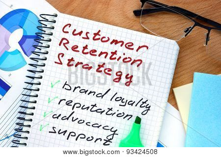 Notepad with words customer retention strategies.