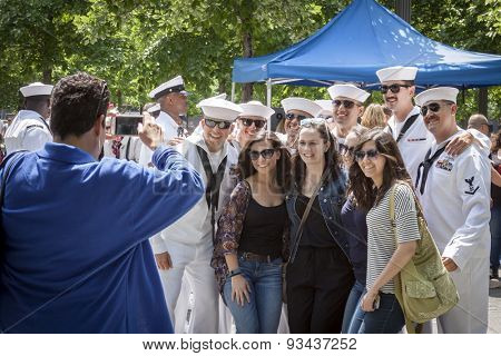 NEW YORK - MAY 22 2015: Group of young women pose with US Navy sailors gathering at the military re-enlistment and promotion ceremony at the National September 11 Memorial site during Fleet Week 2015.